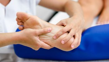 Medical massage at the foot in a physiotherapy center.